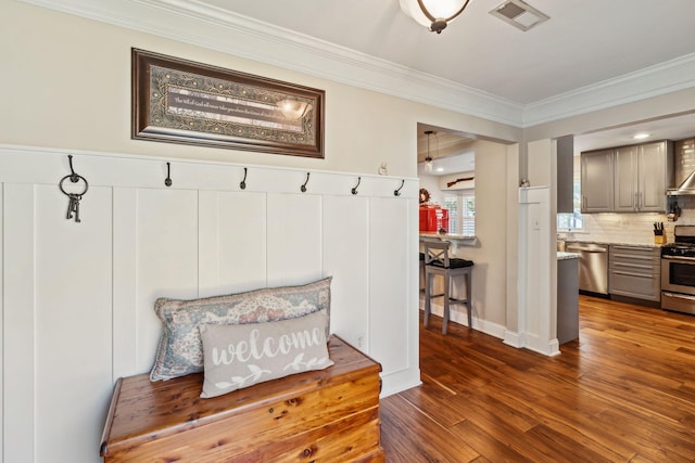 mudroom with ornamental molding, dark wood-style flooring, and visible vents