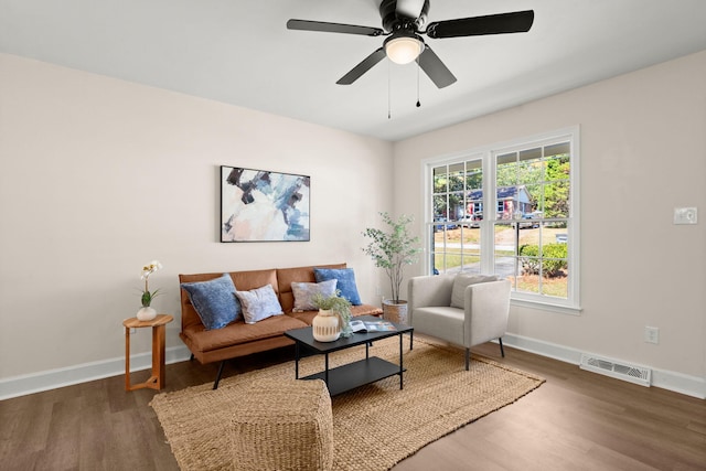 living room with dark wood-type flooring and ceiling fan