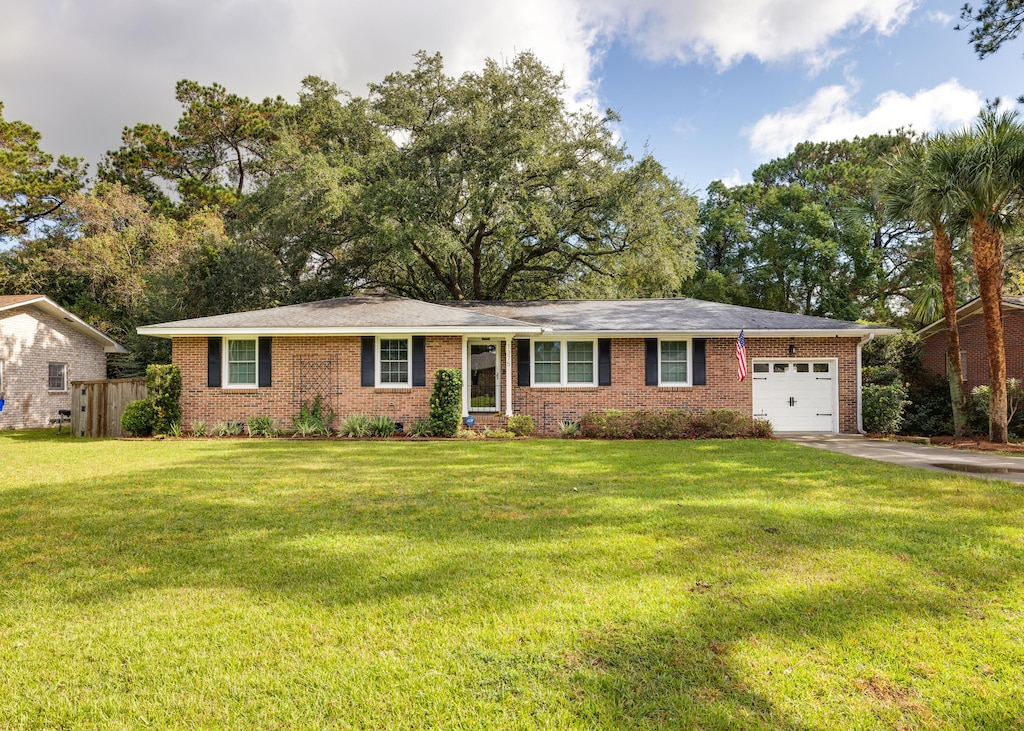 single story home featuring a front lawn and a garage