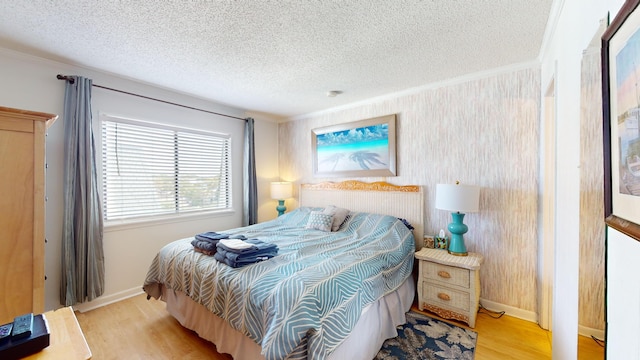 bedroom featuring crown molding, light hardwood / wood-style floors, and a textured ceiling