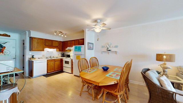 dining area with rail lighting, ornamental molding, sink, light hardwood / wood-style floors, and ceiling fan