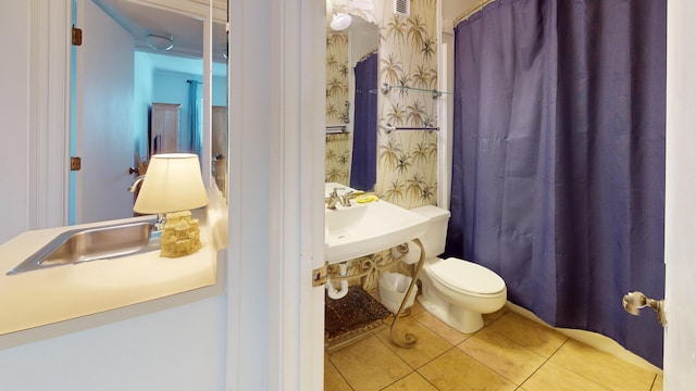 bathroom with sink, toilet, and tile flooring