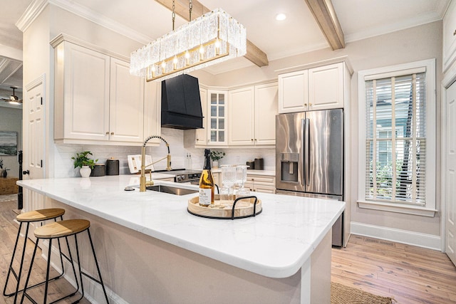 82 Ponsbury Rd, Mount Pleasant, SC 29464 - kitchen with stainless steel refrigerator with ice dispenser, wall chimney exhaust hood, crown molding, light wood-style flooring, and a peninsula