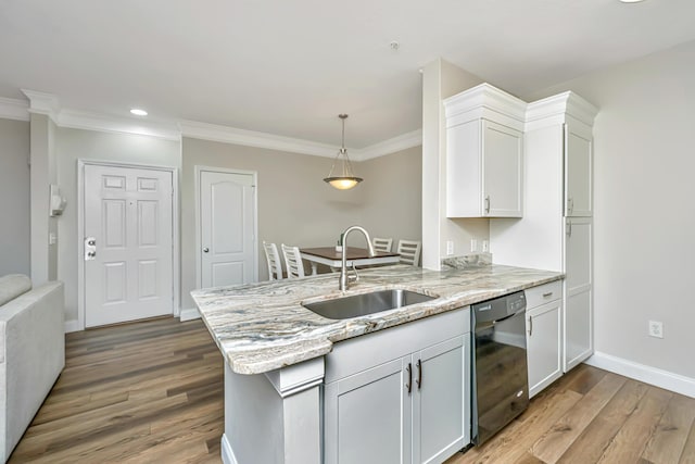 kitchen with light stone countertops, a peninsula, a sink, black dishwasher, and light wood-style floors