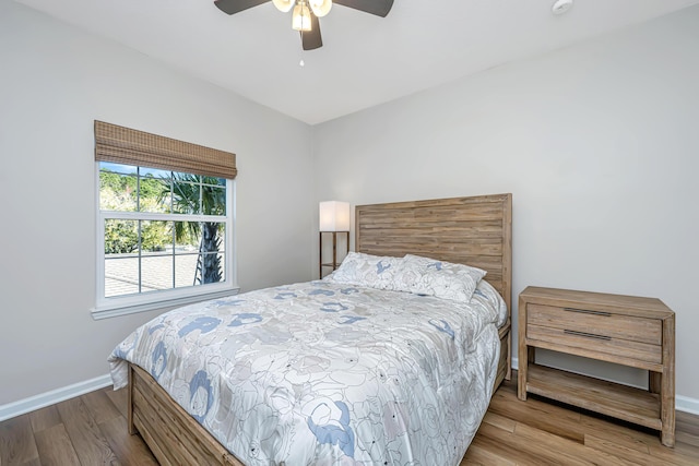 bedroom with ceiling fan, baseboards, and wood finished floors