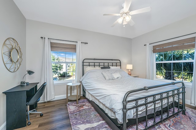 bedroom with multiple windows, wood finished floors, baseboards, and ceiling fan