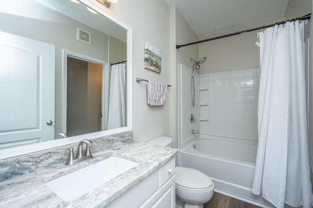 bathroom featuring vanity, wood finished floors, visible vents, shower / bath combination with curtain, and toilet