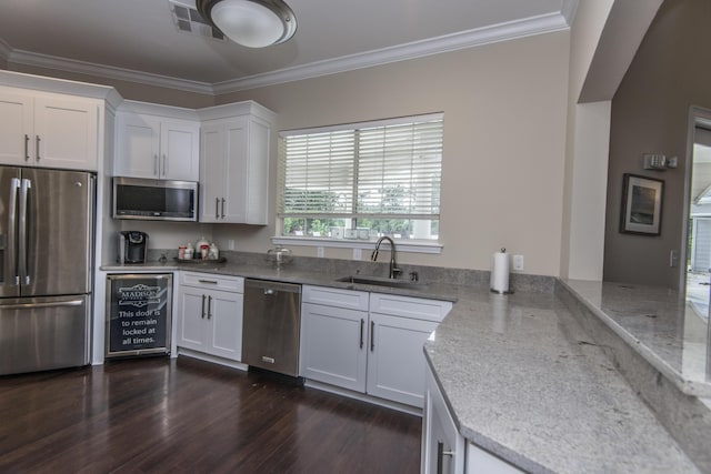 kitchen with crown molding, dark wood finished floors, appliances with stainless steel finishes, white cabinets, and a sink