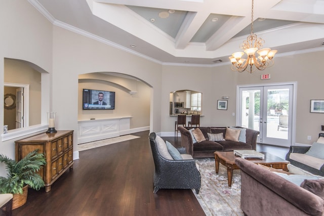 living area with wood finished floors, arched walkways, coffered ceiling, and ornamental molding