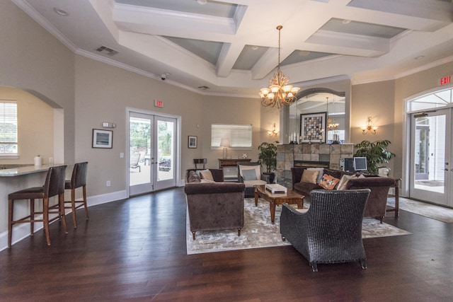 living room with wood finished floors, a high ceiling, a fireplace, french doors, and crown molding