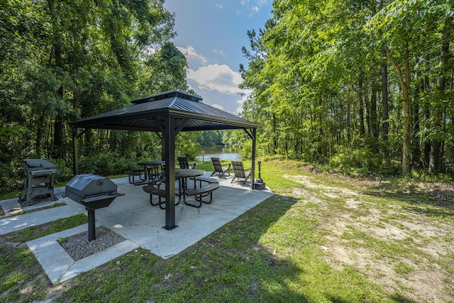 view of yard featuring a gazebo, a patio area, a view of trees, and a water view