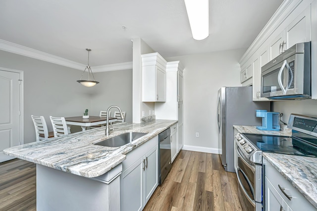 kitchen with light stone counters, dark wood-style floors, a peninsula, a sink, and stainless steel appliances