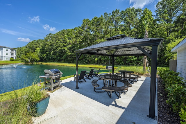 view of patio / terrace with a gazebo, area for grilling, and a water view