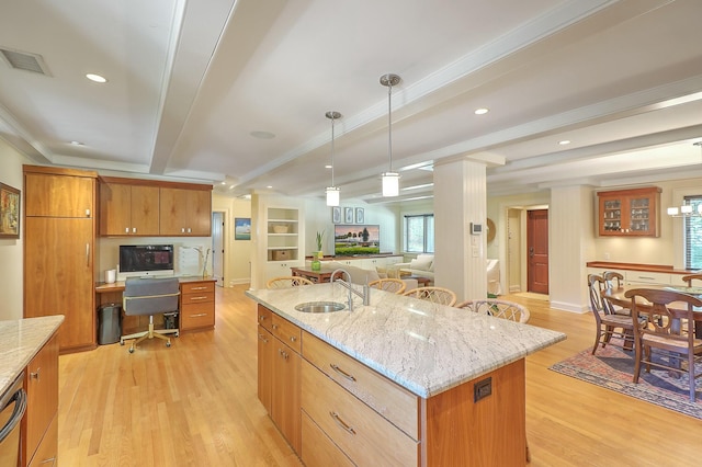 kitchen with a kitchen island, sink, hanging light fixtures, light hardwood / wood-style flooring, and beam ceiling