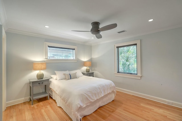 bedroom with ceiling fan, multiple windows, light hardwood / wood-style flooring, and ornamental molding