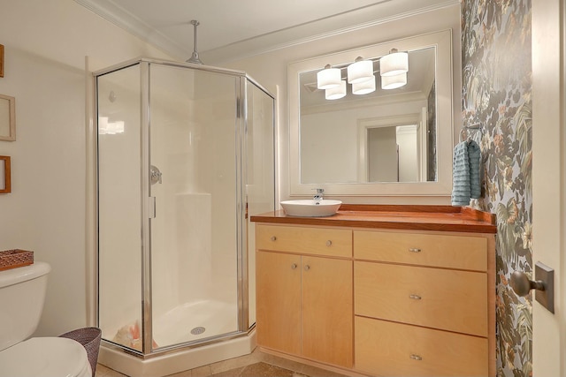 bathroom featuring a shower with shower door, vanity, toilet, and ornamental molding