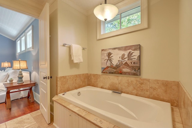 bathroom featuring a relaxing tiled tub, plenty of natural light, and crown molding