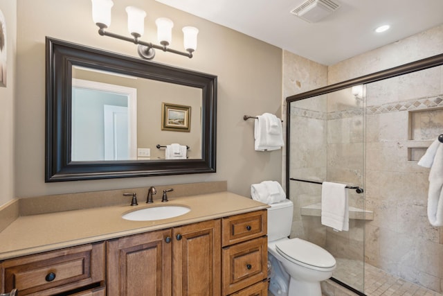 bathroom featuring vanity, toilet, and an enclosed shower