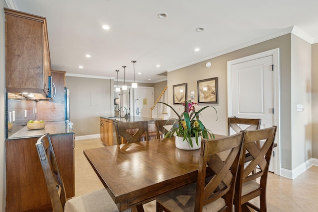 tiled dining space featuring ornamental molding and sink