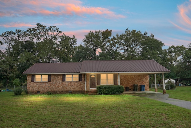 ranch-style home featuring a yard and a carport