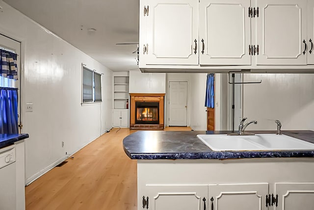 kitchen with sink, light hardwood / wood-style floors, and white cabinets