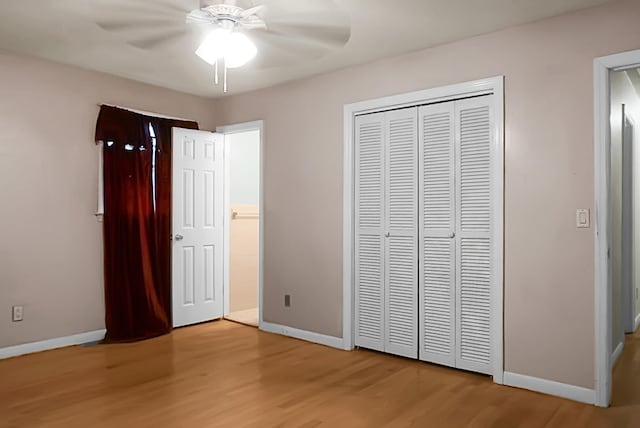 unfurnished bedroom with light wood-type flooring, ceiling fan, and a closet