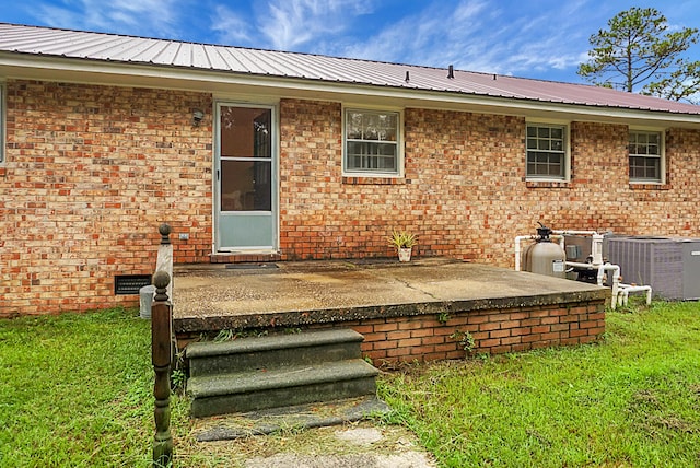 back of house featuring central air condition unit, a patio, and a yard