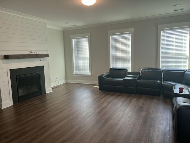 living room featuring plenty of natural light, dark wood-type flooring, and ornamental molding