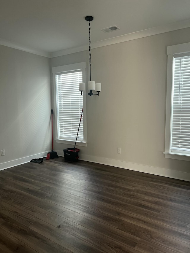 unfurnished dining area featuring a notable chandelier, plenty of natural light, crown molding, and dark wood-type flooring