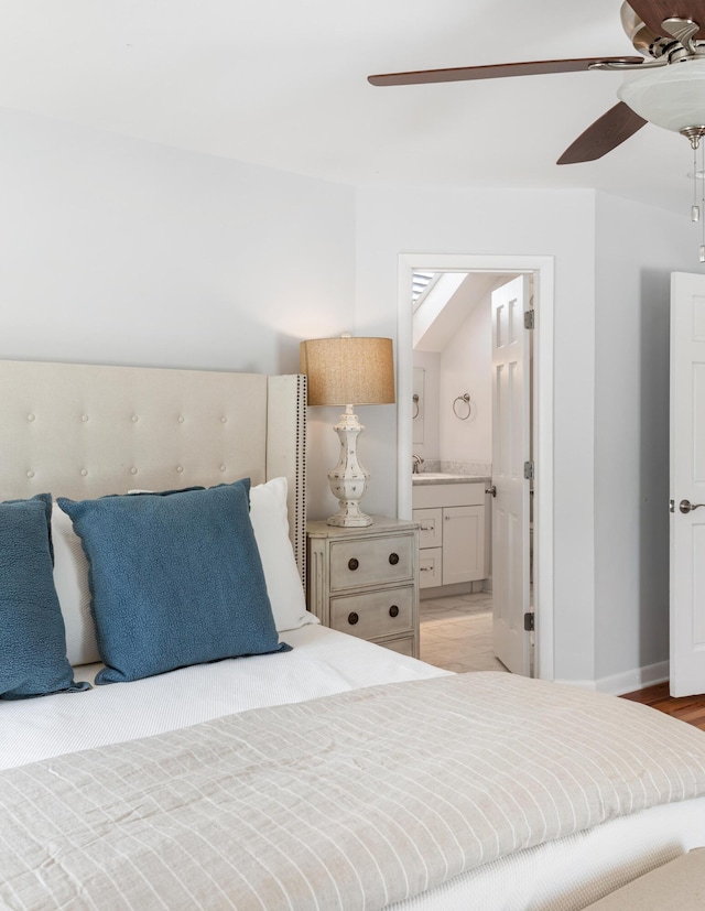 bedroom with ceiling fan, ensuite bathroom, light wood finished floors, and baseboards