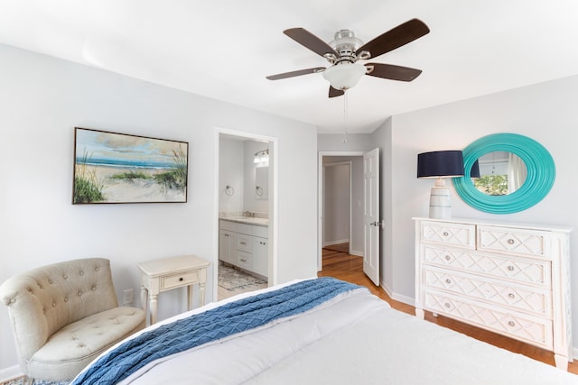 bedroom with light wood-style flooring, a sink, baseboards, a ceiling fan, and ensuite bath