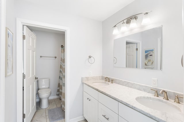 bathroom featuring double vanity, toilet, marble finish floor, and a sink