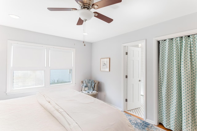 bedroom featuring baseboards, light wood-type flooring, and a ceiling fan