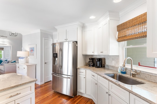 kitchen with white cabinetry, stainless steel fridge, light wood-style flooring, and a sink
