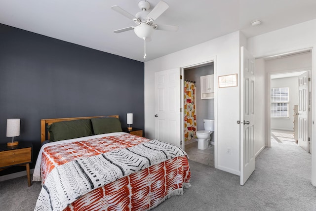 carpeted bedroom featuring ensuite bath and ceiling fan