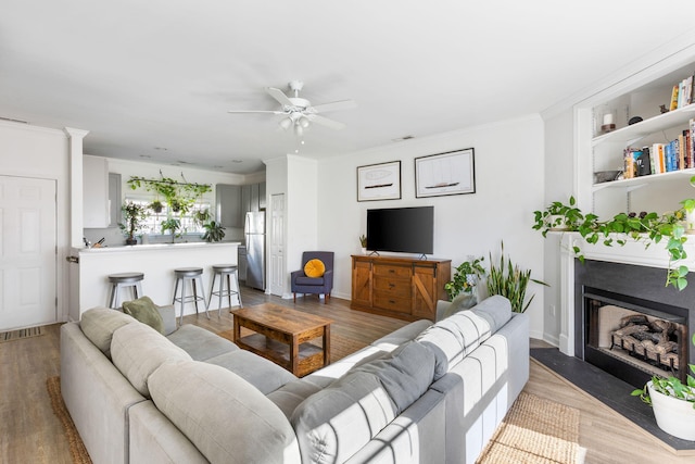 living room featuring ceiling fan and crown molding