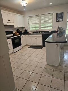 1 Mcclary St, Summerton, SC 29148 - kitchen with electric range, dark countertops, white cabinetry, light tile patterned flooring, and extractor fan