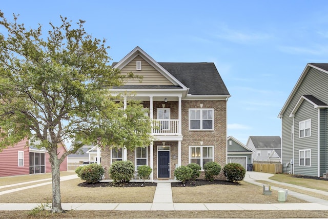 view of front of property featuring brick siding, a shingled roof, and a balcony