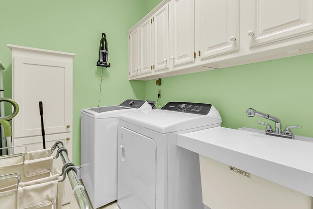 washroom with washer and clothes dryer and cabinet space