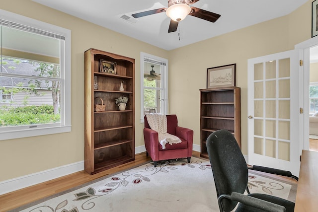 office space featuring wood finished floors, ceiling fan, and baseboards