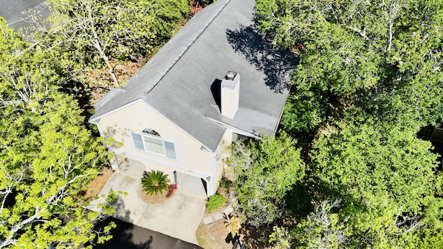 view of subject property featuring a tree filled landscape