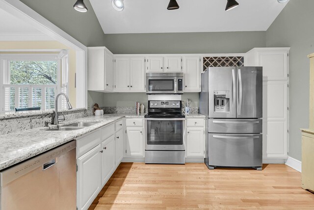 kitchen with appliances with stainless steel finishes, a sink, and white cabinets