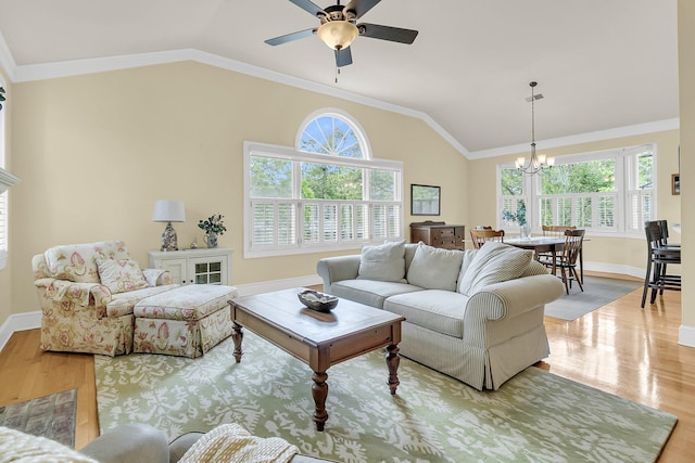 living room featuring vaulted ceiling, a chandelier, light wood-type flooring, baseboards, and ceiling fan