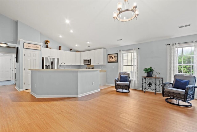 3486 Ashwycke St, Mount Pleasant, SC 29466 - kitchen with stainless steel appliances, light wood-style flooring, white cabinetry, a chandelier, and vaulted ceiling
