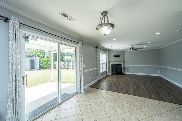 unfurnished living room featuring light wood-type flooring, ornamental molding, and ceiling fan