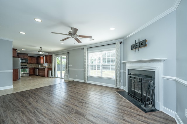 unfurnished living room with crown molding, ceiling fan, and dark hardwood / wood-style floors