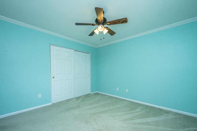 unfurnished bedroom featuring ceiling fan, ornamental molding, a closet, and carpet floors