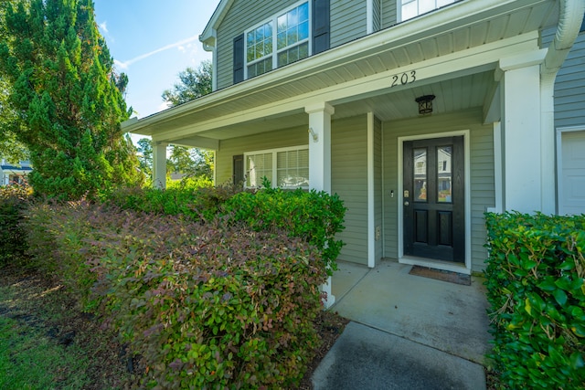 view of exterior entry with a porch