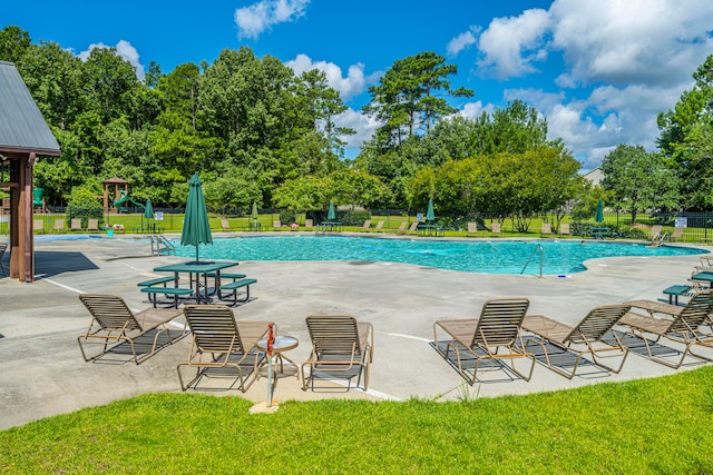 view of swimming pool with a yard and a patio