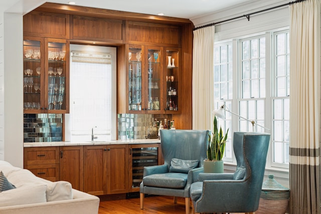 bar featuring wine cooler, sink, decorative backsplash, and plenty of natural light